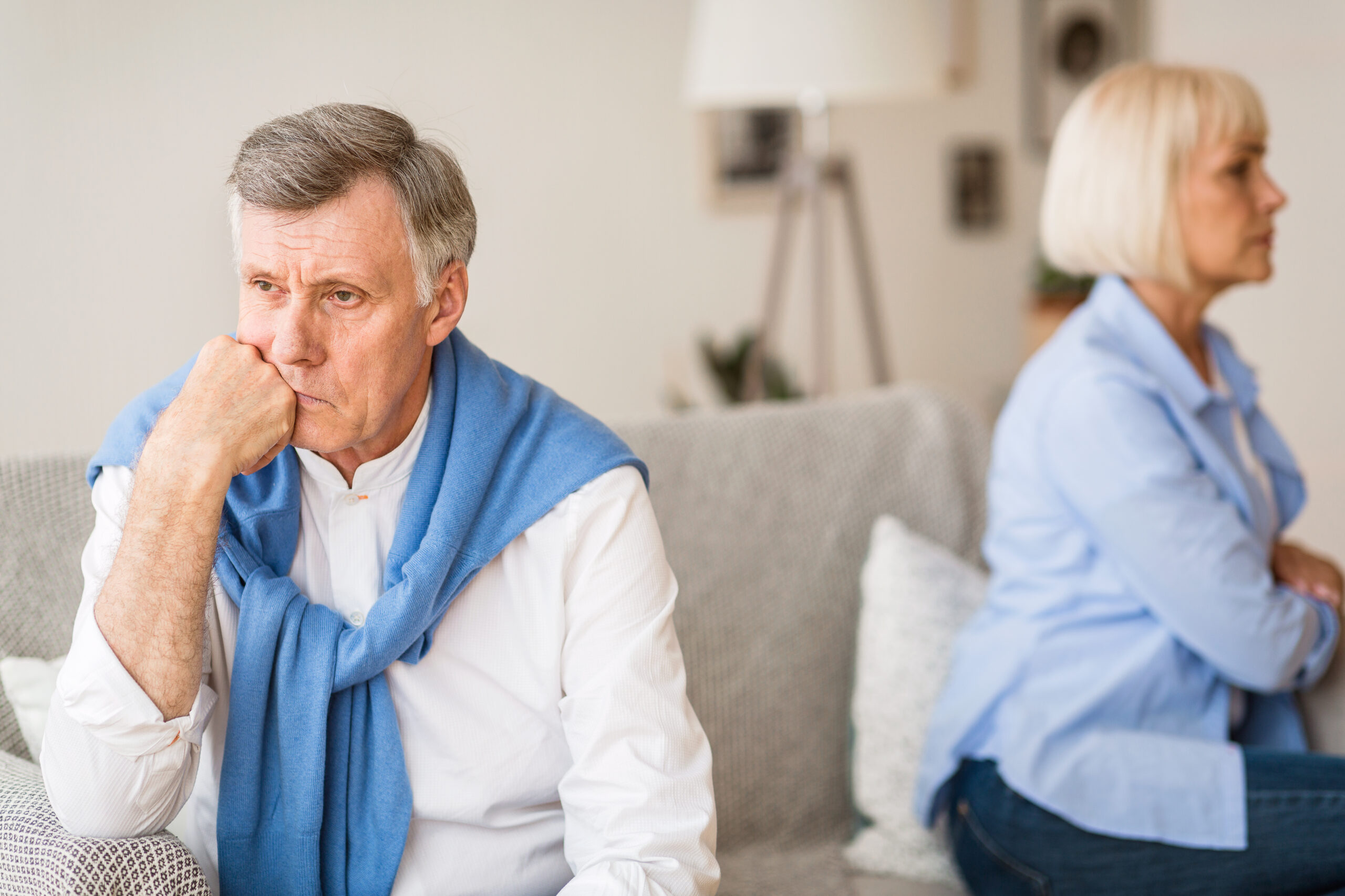 gray divorce older couple sitting facing away from each other on couch