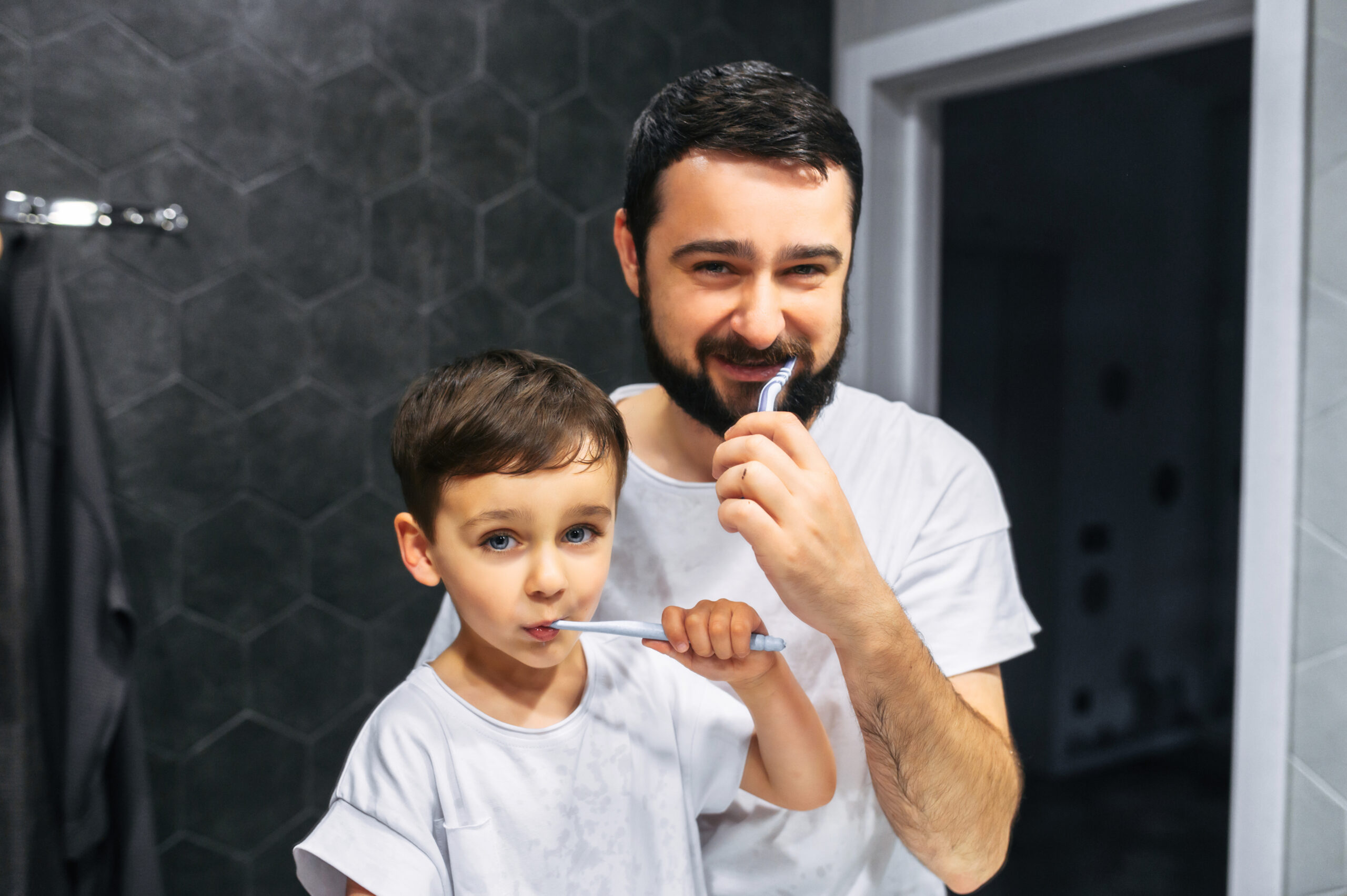 parent brushing teeth with child