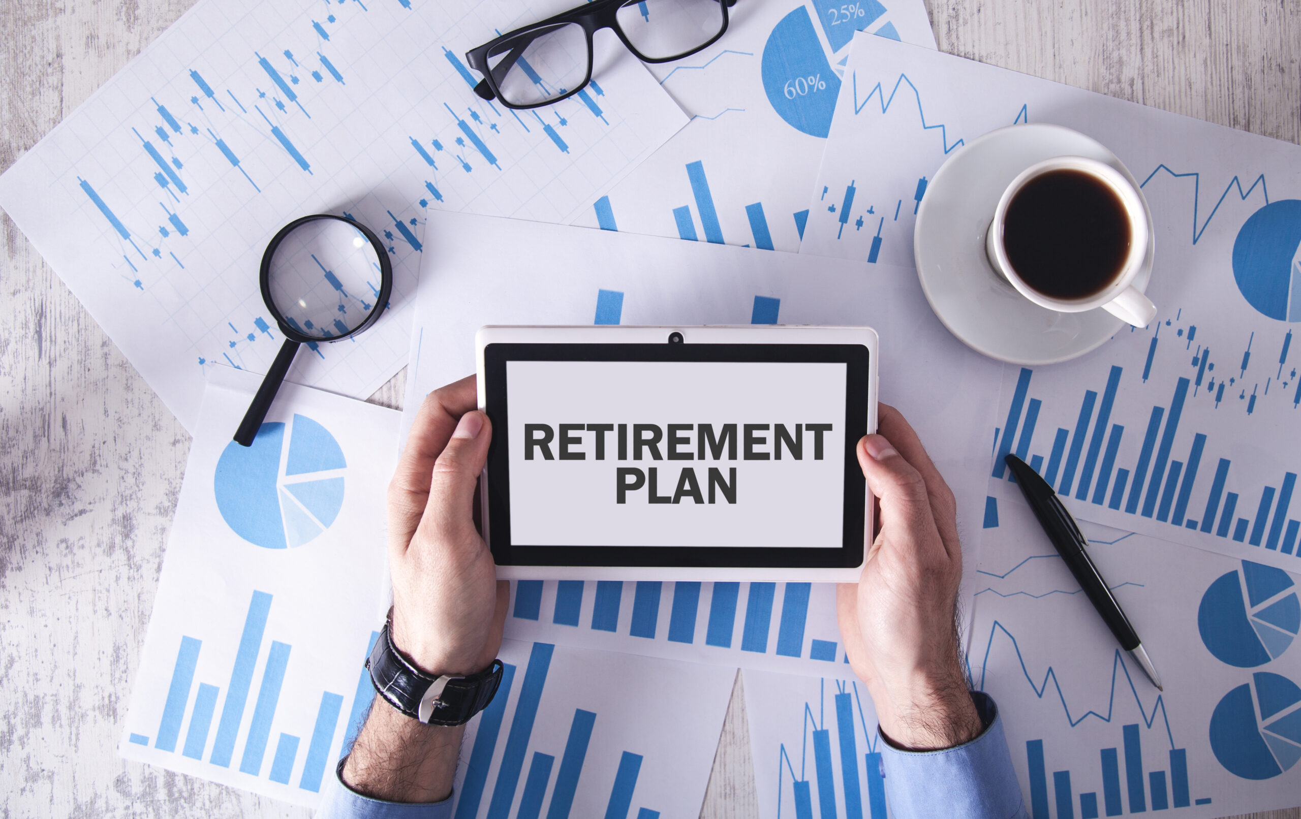 Man holding tablet with text Retirement Plan on tablet screen.