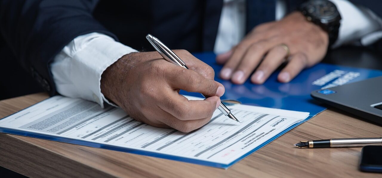 Attorney's hands filling out divorce paperwork; Monmouth County, NJ Business Owner Divorce Attorney concept image
