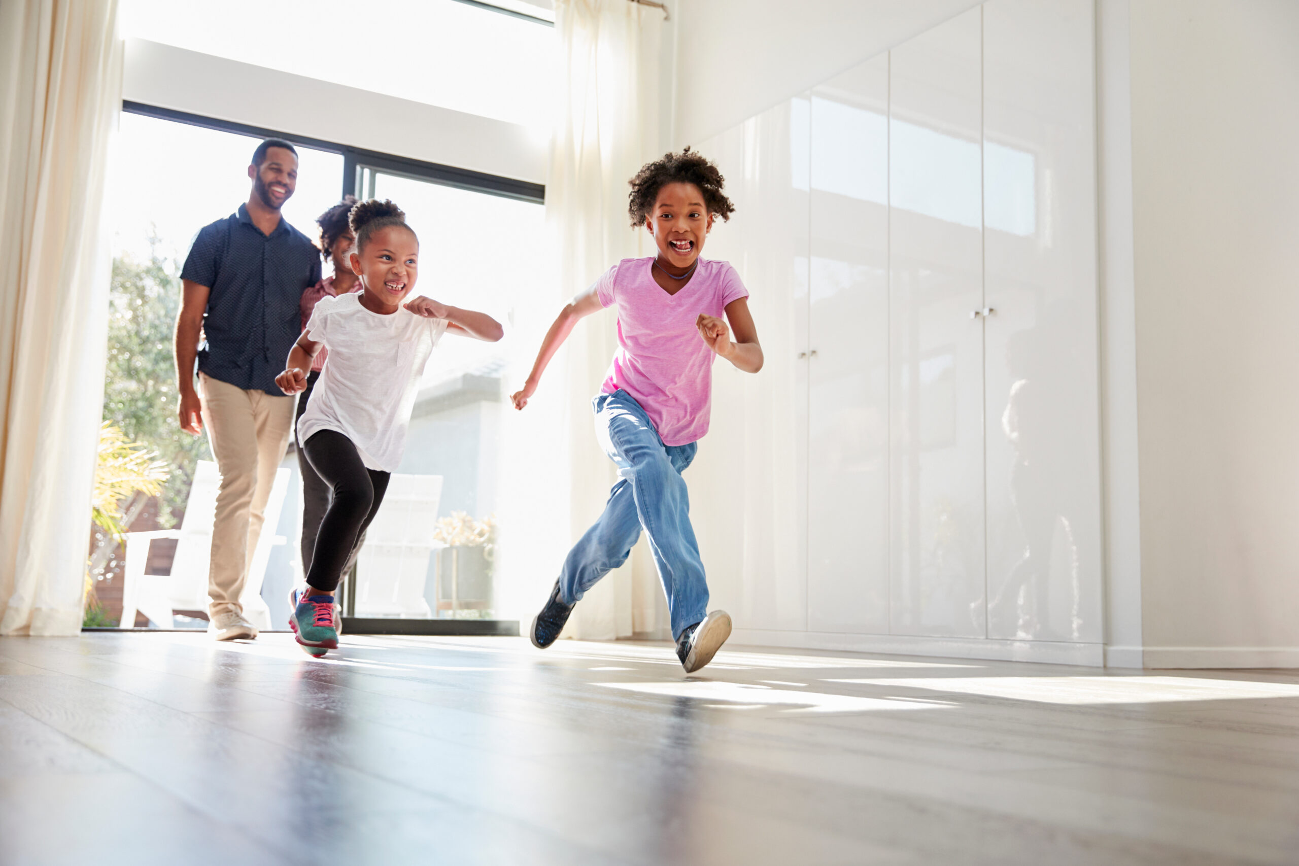 Excited Family Exploring New Home On Moving Day